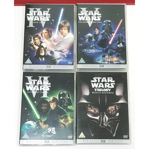 81 - A bundle of Star Wars collectables. To include three framed posters, VHS videos, DVD's, figures and ... 