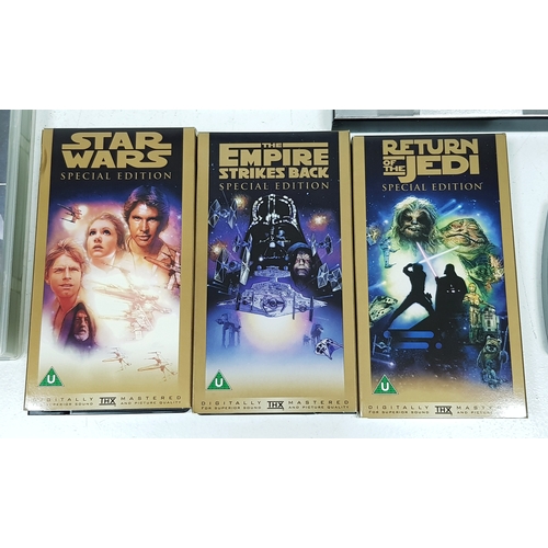 81 - A bundle of Star Wars collectables. To include three framed posters, VHS videos, DVD's, figures and ... 