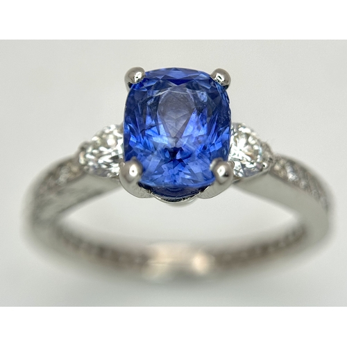 113 - A Dazzling 950 Platinum Sapphire and Diamond Ring. A 1.75ct cushion mixed cut sapphire with thirty-f... 
