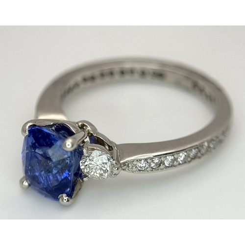 113 - A Dazzling 950 Platinum Sapphire and Diamond Ring. A 1.75ct cushion mixed cut sapphire with thirty-f... 