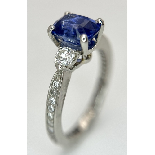 113 - A Dazzling 950 Platinum Sapphire and Diamond Ring. A 1.75ct cushion mixed cut sapphire with thirty-f... 
