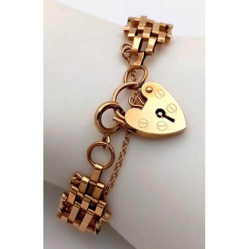 74 - A 9K Yellow Gold Gate Link Bracelet with Heart Clasp. 13mm width. 18cm length. 9.82g.