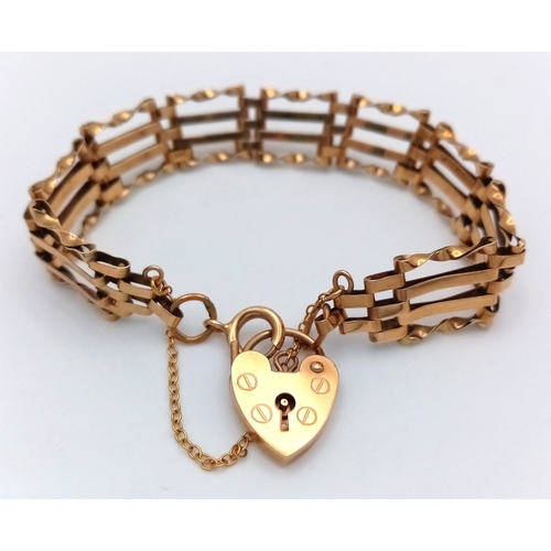 74 - A 9K Yellow Gold Gate Link Bracelet with Heart Clasp. 13mm width. 18cm length. 9.82g.