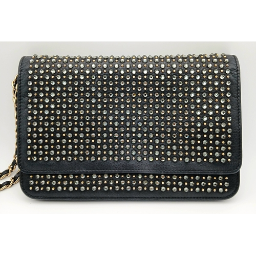 78 - A Chanel Studded Leather Wallet on Chain / Clutch. Crafted from black grained leather, the exterior ... 