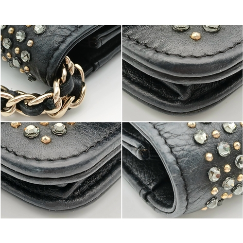 78 - A Chanel Studded Leather Wallet on Chain / Clutch. Crafted from black grained leather, the exterior ... 