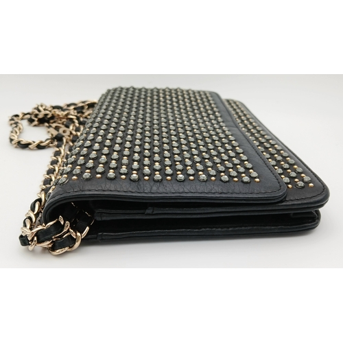 78 - A Chanel Studded Leather Wallet on Chain / Clutch. Crafted from black grained leather, the exterior ... 