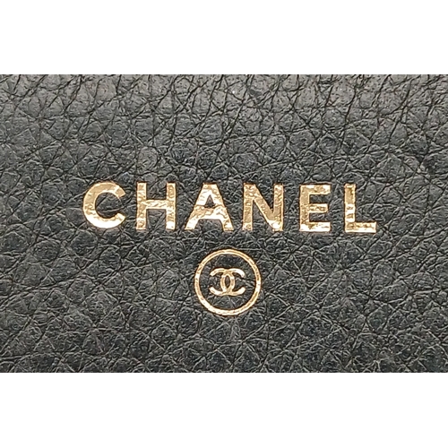 78 - A Chanel Studded Leather Wallet on Chain / Clutch. Crafted from black grained leather, the exterior ... 