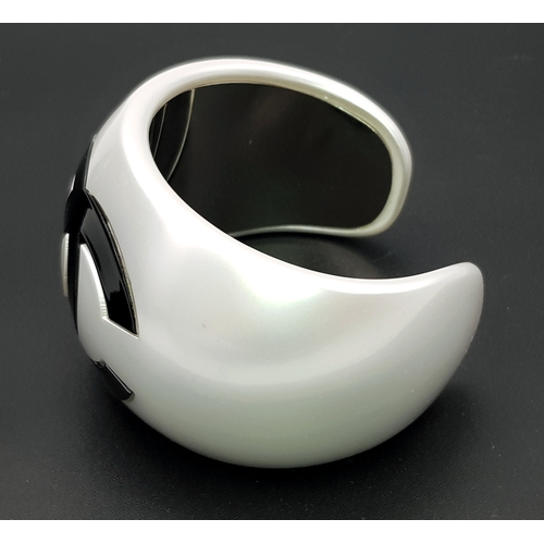 104 - A Chanel Limited Edition Black and Pearl Resin CC Cuff Bracelet. 5cm width at its widest. 57mm inner... 