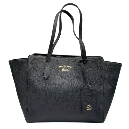 211 - A Gucci Swing Tote Bag. Black grained leather exterior with dual shoulder straps, detachable leather... 