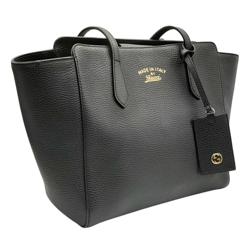211 - A Gucci Swing Tote Bag. Black grained leather exterior with dual shoulder straps, detachable leather... 