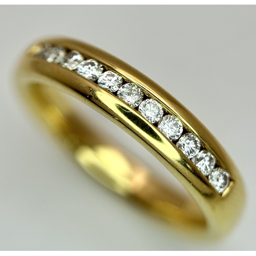 219 - An 18K Yellow Gold and Diamond Half Eternity Ring. Size N. Channel set round brilliant cut diamonds.... 