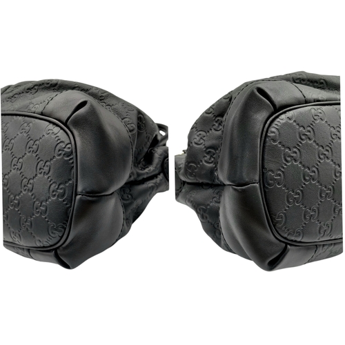 232 - A Gucci Guccissima Sukey Handbag. Black GG monogram embossed leather exterior with silver-tone hardw... 