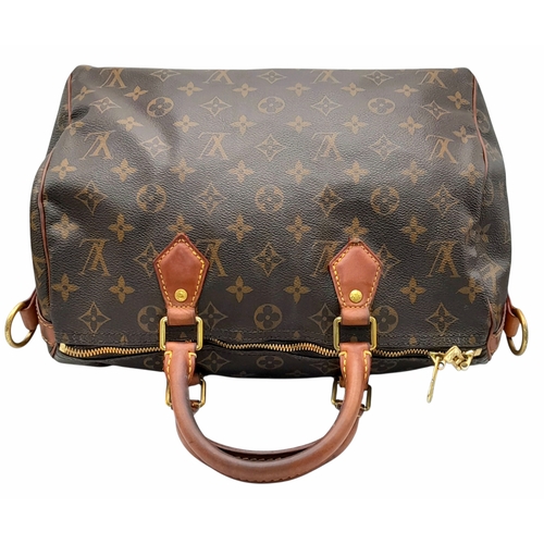 303 - A Louis Vuitton Monogram Speedy 30 Handbag. Signature brown monogram coated canvas exterior with vac... 