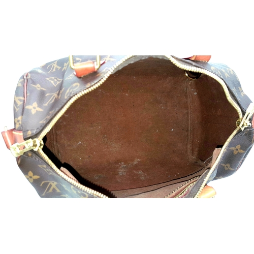 303 - A Louis Vuitton Monogram Speedy 30 Handbag. Signature brown monogram coated canvas exterior with vac... 