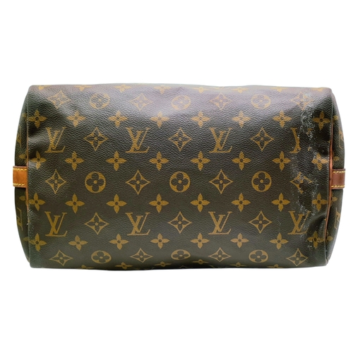 303 - A Louis Vuitton Monogram Speedy 30 Handbag. Signature brown monogram coated canvas exterior with vac... 