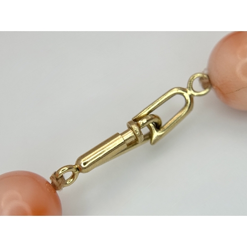 356 - An 18K Gold and Red Coral Necklace. 8mm coral beads. 60cm necklace length. 50.6g. MT16.