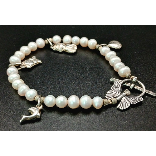 108 - A pretty 925 silver charm and freshwater pearl bracelet. Approx 17cm length. Please see photos for d... 