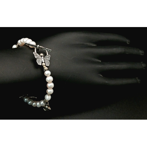 108 - A pretty 925 silver charm and freshwater pearl bracelet. Approx 17cm length. Please see photos for d... 