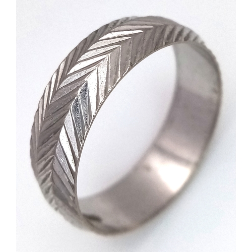 3 - An 18K White Gold Band Ring. Textured chevron exterior band pattern. Size T 1/2. 7mm width. 5.6g.