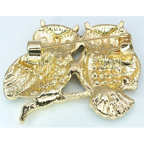 318 - An Eye-catching Owl Design Brooch. Featuring two owls perched together, decorated with enamel detail... 