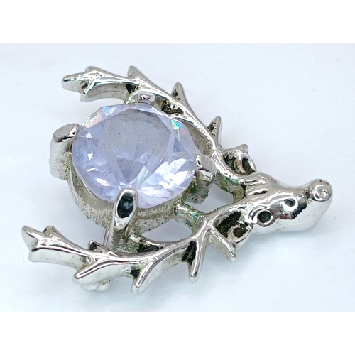 71 - A Deer Head Brooch with Blue Stone. Set with a central round-cut blue stone within a stag head desig... 