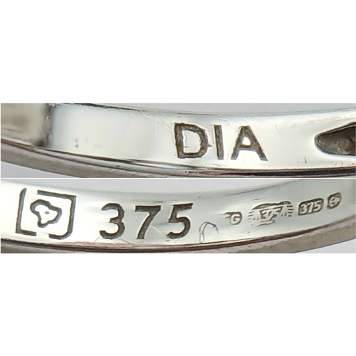 1162 - An Attractive 9K White Gold Blue Topaz and Diamond Set Ring Size M1/2. The Ring is set with a 7mm Lo... 