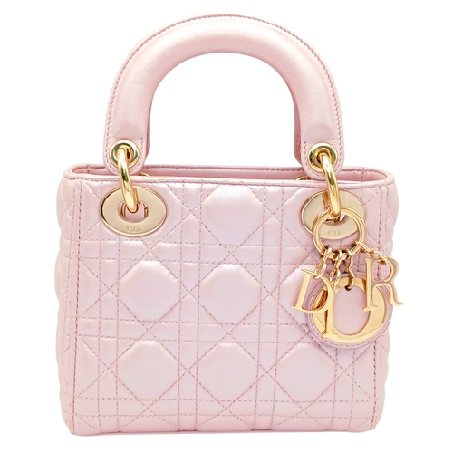 A Pink Lady Dior Cannage Leather Mini Handbag. Pink leather exterior with gold-tone hardware, top handles, detachable shoulder strap and flap closure. Beigh leather interior with one main compartment and a zipped side pocket. Some marks and scratches to the leather. Approx 17cm length x 15cm height x 7cm depth. Comes with dust cover and box. Please see photos or request a condition report.