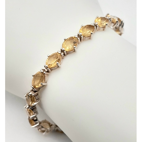 720 - An Elegant Sterling Silver and Citrine Set Tennis Bracelet-18.5cm Length. Set with Twenty 6 x 5mm Ov... 