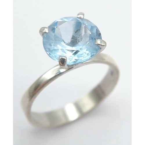 1211 - A Stylish Sterling Silver Tiffany Style Mounted Blue Topaz Solitaire Ring Size Q. The Ring is set wi... 