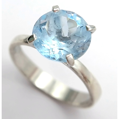 1211 - A Stylish Sterling Silver Tiffany Style Mounted Blue Topaz Solitaire Ring Size Q. The Ring is set wi... 