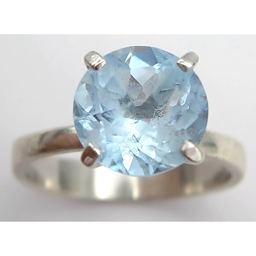 1211 - A Stylish Sterling Silver Tiffany Style Mounted Blue Topaz Solitaire Ring Size Q. The Ring is set wi... 
