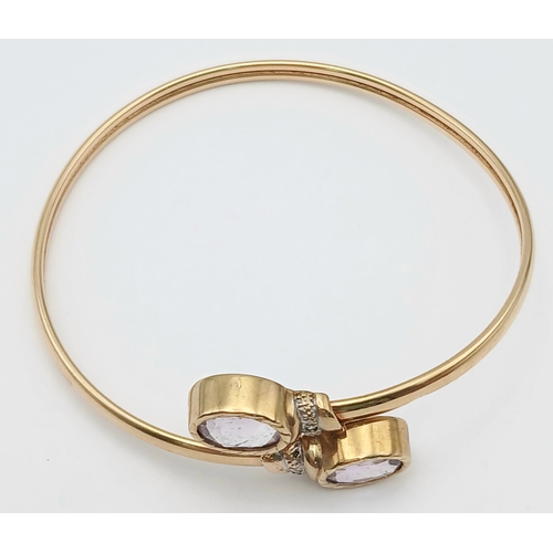 51 - A 9K GOLD TORQUE STYLE BANGLE WITH 2 PALE AMETHYST STONES , (ONE SMALL KINK HENCE LOW PRICE)    8.8g... 