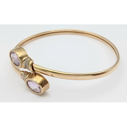 51 - A 9K GOLD TORQUE STYLE BANGLE WITH 2 PALE AMETHYST STONES , (ONE SMALL KINK HENCE LOW PRICE)    8.8g... 