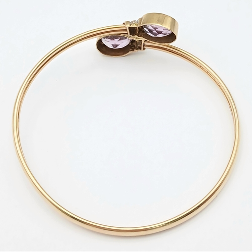 51 - A 9K GOLD TORQUE STYLE BANGLE WITH 2 PALE AMETHYST STONES , (ONE SMALL KINK HENCE LOW PRICE)    8.8g... 