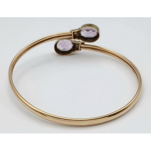 51 - A 9K GOLD TORQUE STYLE BANGLE WITH 2 PALE AMETHYST STONES , (ONE SMALL KINK HENCE LOW PRICE)    8.8g... 