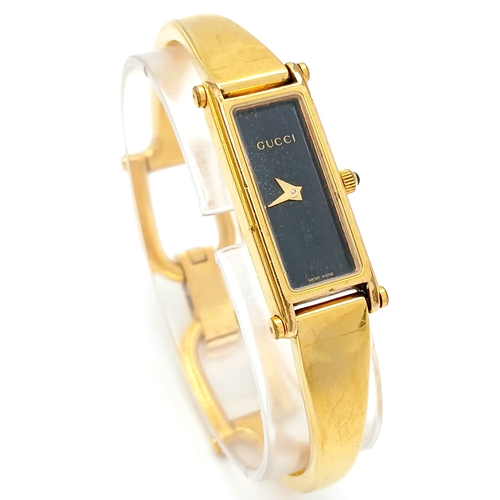 649 - A LADIES GUCCI, GOLD TONE BANGLE WATCH. MODEL 1500L. IN FULL WORKING ORDER, NEW BATTERY FITTED RECEN... 