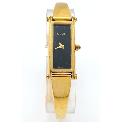 649 - A LADIES GUCCI, GOLD TONE BANGLE WATCH. MODEL 1500L. IN FULL WORKING ORDER, NEW BATTERY FITTED RECEN... 