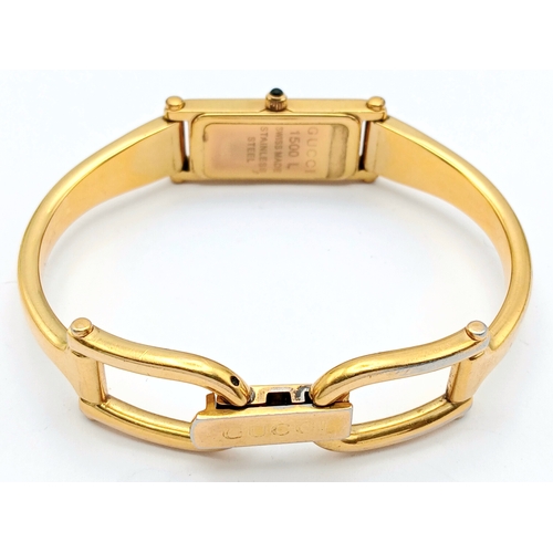 649 - A LADIES GUCCI, GOLD TONE BANGLE WATCH. MODEL 1500L. IN FULL WORKING ORDER, NEW BATTERY FITTED RECEN... 