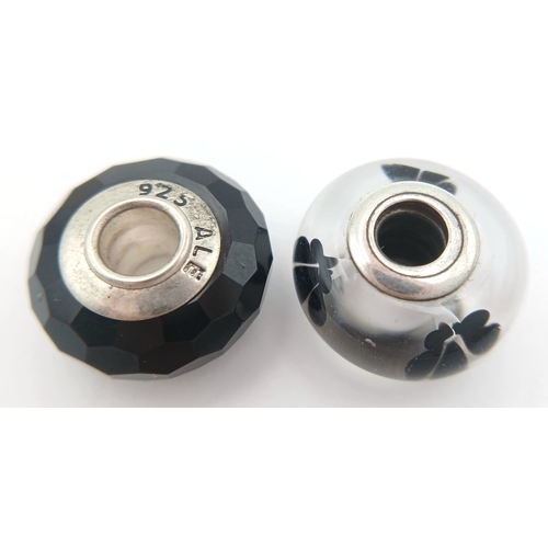 705 - A PAIR OF PANDORA, STERLING SILVER CHARMS. BLACK MURANO GLASS AND BLACK CHERRY BLOSSOM MURANO GLASS.... 