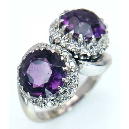 9 - A STUNNING 18K WHITE GOLD CROSSOVER RING WITH 2 X 2cwt OF ALEXANDRITE STONES SURROUNDED BY A HALO OF... 