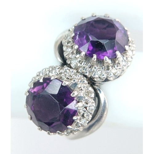 9 - A STUNNING 18K WHITE GOLD CROSSOVER RING WITH 2 X 2cwt OF ALEXANDRITE STONES SURROUNDED BY A HALO OF... 