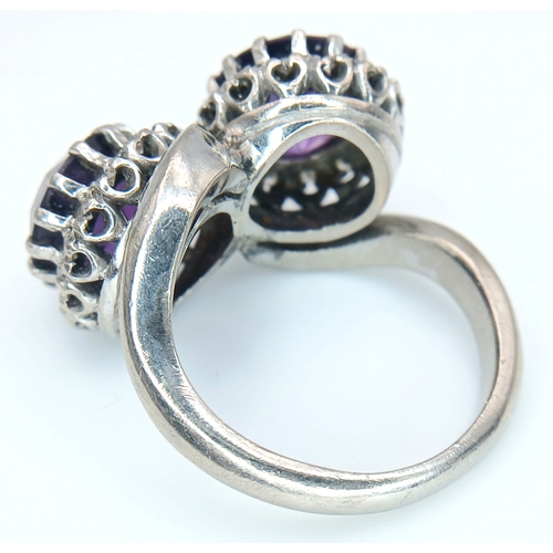 9 - A STUNNING 18K WHITE GOLD CROSSOVER RING WITH 2 X 2cwt OF ALEXANDRITE STONES SURROUNDED BY A HALO OF... 