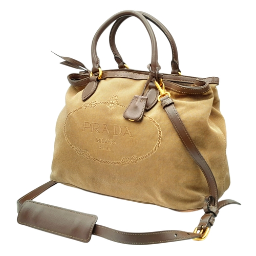 1216 - A Prada Beige Canvas and Brown Leather Tote Bag. Crafted in beige canvas with an embroidered “PRADA ... 