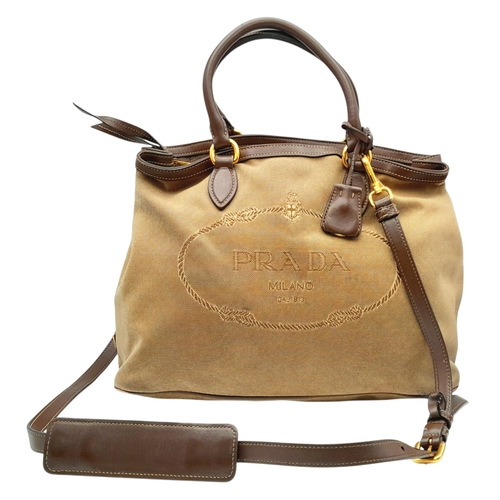 1216 - A Prada Beige Canvas and Brown Leather Tote Bag. Crafted in beige canvas with an embroidered “PRADA ... 