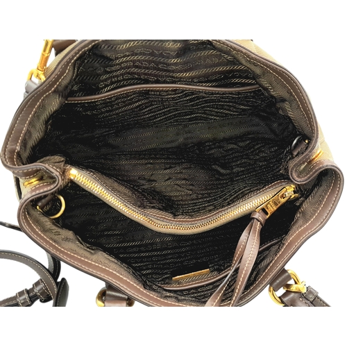 1216 - A Prada Beige Canvas and Brown Leather Tote Bag. Crafted in beige canvas with an embroidered “PRADA ... 