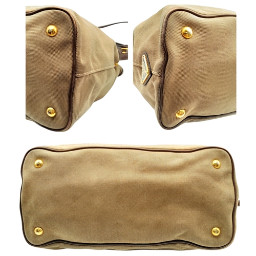 1216 - A Prada Beige Canvas and Brown Leather Tote Bag. Crafted in beige canvas with an embroidered “PRADA ... 
