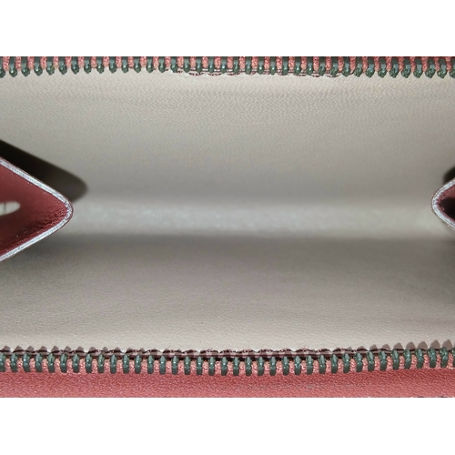 1241 - A Bottega Veneta Burgundy Wallet. Intrecciato leather exterior with gold-toned hardware, zipped coin... 