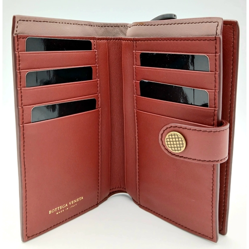 1241 - A Bottega Veneta Burgundy Wallet. Intrecciato leather exterior with gold-toned hardware, zipped coin... 
