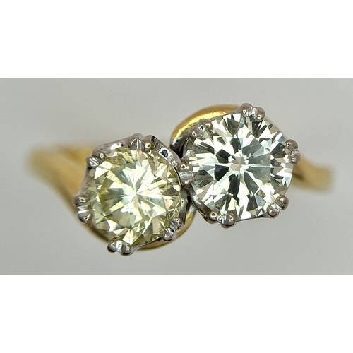 674 - An 18K Yellow Gold Diamond Crossover Ring. A 1ct round brilliant cut diamond having I colour and com... 