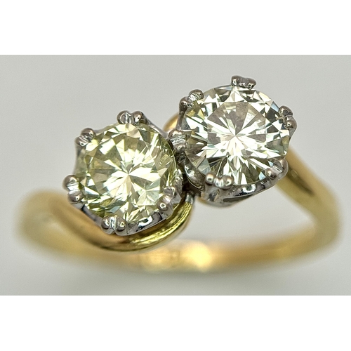 674 - An 18K Yellow Gold Diamond Crossover Ring. A 1ct round brilliant cut diamond having I colour and com... 